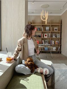 a woman sitting on top of a bed next to a teddy bear in a room