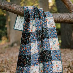 a blue and white quilt hanging on a tree branch