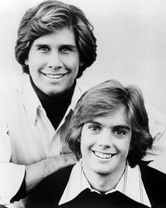 two young men are posing for a black and white photo