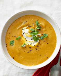 a white bowl filled with soup and topped with an egg