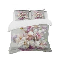 a bed with white and pink flowers on the comforter, pillows and pillow cases