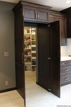 an open pantry door in the middle of a kitchen