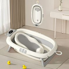 an inflatable bathtub is sitting on the floor next to some rubber ducks