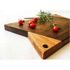 a wooden cutting board topped with tomatoes on top of a table