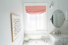 a bathroom with a sink, mirror and bathtub in it next to a window