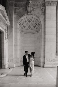 a man and woman standing in front of a building