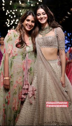 two women standing next to each other on a runway