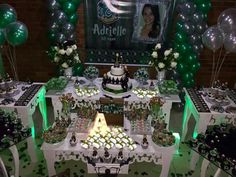 a table topped with lots of cake and cupcakes covered in green frosting