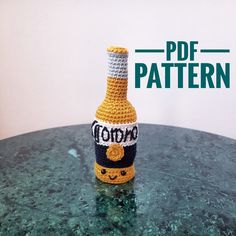 a crocheted bottle sitting on top of a green table next to a white wall