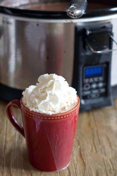 a red mug filled with whipped cream next to an instant pot