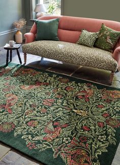 a living room filled with furniture and pillows on top of a green rug covered floor