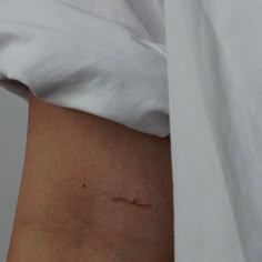 a small tattoo on the side of a woman's stomach