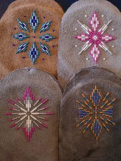 three hats with beaded designs on them sitting next to each other in the shape of snowflakes