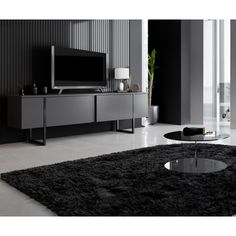 a black and white living room with a large tv on the wall above it's entertainment center