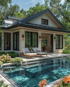 a house with a pool in front of it and some flowers around the pool area