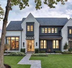 a large white brick house with lots of windows on the front and side of it