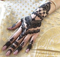 a woman's hand with henna tattoos on it