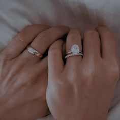 two hands holding each other while wearing wedding rings