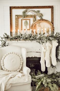 a living room decorated for christmas with stockings on the mantel and candles in the fireplace