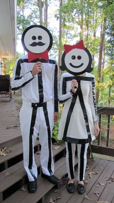 two people dressed up in costumes standing on steps with their faces painted black and white