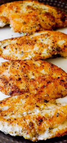 three pieces of chicken on a plate with seasoning sprinkled over them and sitting next to each other