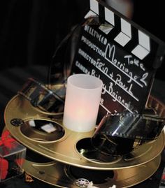 a candle is sitting on top of a movie clapper and some other movies are around it