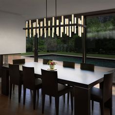 a dining room table and chairs with lights hanging from the ceiling