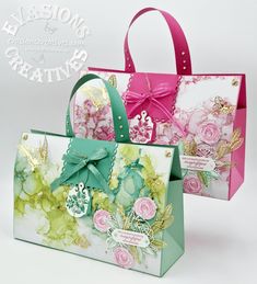 two bags with flowers on them are sitting side by side, one is green and the other is pink