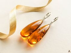 "Natural Baltic amber cognac color earrings is a perfect choice for classy style admirers! Shaped in drop form these earrings look delicate yet fancy. MATERIALS AND SIZE: Stone: 100% Natural Baltic Amber Findings: Sterling silver 925 Earrings A: Weight: 10,3 g (0,36 oz) Bead size: 4,3 cm (1,69 in) x 1,6 cm (0,63 in) Total earring length: 6,3 cm ( 2,48 in) Earrings B: Weight: 9,4 g (0,33 oz) Bead size: 4,9 cm (1,93 in) x 1,7 cm (0,67 in) Total earring length: 6,8 cm ( 2,68 in) PLEASE NOTE: All ou Handmade Elegant Teardrop Earrings, Luxury Amber Drop Earrings, Orange Teardrop Jewelry For Formal Occasions, Handmade Dangle Teardrop Earrings For Formal Occasions, Handmade Elegant Long Drop Teardrop Earrings, Modern Amber Earrings For Formal Occasions, Handmade Teardrop Dangle Earrings For Formal Occasions, Modern Amber Earrings For Formal Events, Handmade Teardrop Earrings For Formal Occasions