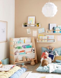 a child's bedroom with bookshelves and toys on the floor in it