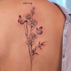 a woman's back with flowers and butterflies on it