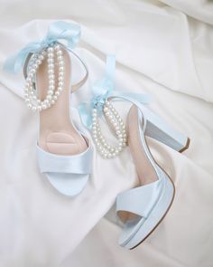 An all time classic and elegance with simplicity of satin block heels sandal adorned with double pearls ankle strap for a sweet and romantic look. Perfect for brides, bridesmaids, prom night, date night, and definitely a highlight on every special occasions. The delicate pearl beads are placed carefully by hand made to order to create a graceful classic bridal shoe. DETAILS: HEELS: 4 inches COLORS AVAILABLE: Ivory, White, Light Blue,  Black, Champagne UPPER: Synthetic upper and lining MATERIALS: Manmade outsole ORIGIN: Imported STYLE NAME: ATHENA  Not sure of which size to purchase? Shoes measurements are as follow: (Please note measurements taken the length of inside of shoe from toe to heel) SIZE 5 - 9" SIZE 6 - 9.25" SIZE 7 - 9.5" SIZE 8 - 9.875" SIZE 9 - 10.25" SIZE 10 - 10.50"  SIZE 1 Wedding Shoes Bride Something Blue, White Heels With Blue Flowers, Light Blue High Heels Quinceanera, Wedding Shoes Light Blue, Bride Platform Heels, Quinceanera Shoes Heels Blue, Prom Shoes Short Heel, Light Blue Prom Heels, Light Blue Prom Shoes