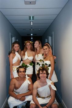 a group of people dressed in white posing for a photo