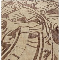 an abstractly designed area rug in brown and beige colors with circular designs on it