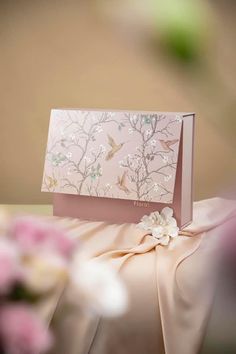 a card that is sitting on top of a table with flowers in front of it