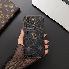 a woman is holding her louis vuitton phone case while sitting at a desk