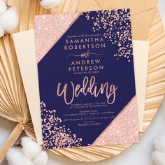 a blue and pink wedding card with gold glitters on it next to cotton flowers