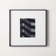 a black and white photo hanging on the wall next to a framed art print with an abstract geometric design