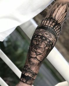 a man's arm with a lion tattoo on it and an eagle in the middle