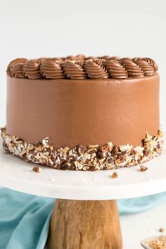 a chocolate frosted cake with nuts on top