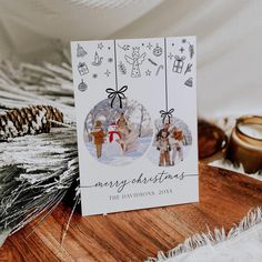 a merry christmas card on a wooden table with other decorations and candles in the background