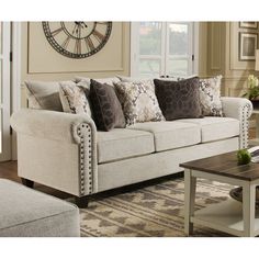 a living room filled with furniture and a clock on the wall above it's windows