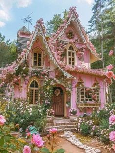 a pink house with lots of flowers around it