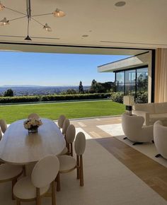 a dining room table and chairs in front of a large window with an expansive view