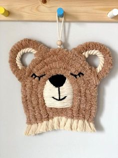 a brown teddy bear hanging on a wall