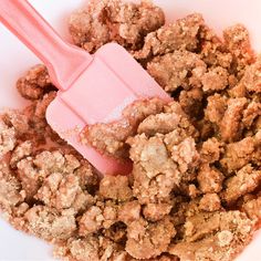 a pink spatula in a bowl filled with crumbs