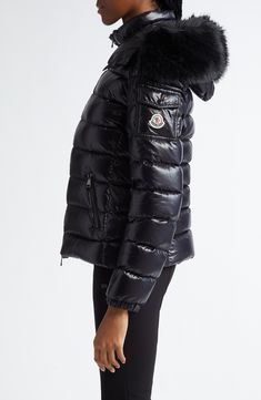 The label's elevated mountaineering aesthetic takes a glamorous twist in this glossy nylon puffer boasting plush down insulation and a detachable hood traced with removable faux fur. Two-way front-zip closure Stand collar; removable hood with faux-fur trim Front zip pockets; sleeve snap-flap patch pocket Nylon lining, with 90% down, 10% feather fill (Armenia) 100% nylon with 100% polyester faux fur Dry clean Made in Armenia Designer Clothing Luxury Black Puffer Jacket With Zipper Closure, Luxury Black Puffer Jacket With Detachable Hood, Luxury Black Down Puffer Jacket, Luxury Down Puffer Jacket For Outdoor, Luxury Fitted Puffer Jacket For Outdoor, Luxury Nylon Puffer Jacket For Outdoor, Luxury Down Puffer Jacket With Detachable Hood, Luxury Nylon Puffer Jacket For Cold Weather, Mountaineering Aesthetic