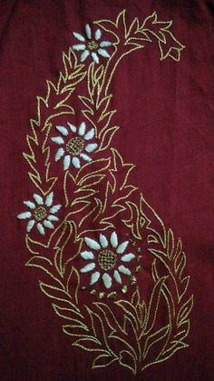 an embroidered design on a red cloth with white and blue flowers in the center, surrounded by gold thread