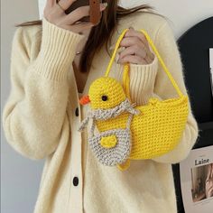 a woman taking a selfie while holding a yellow bag with a duck on it