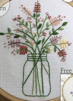 a vase filled with lots of flowers on top of a white cloth covered tablecloth